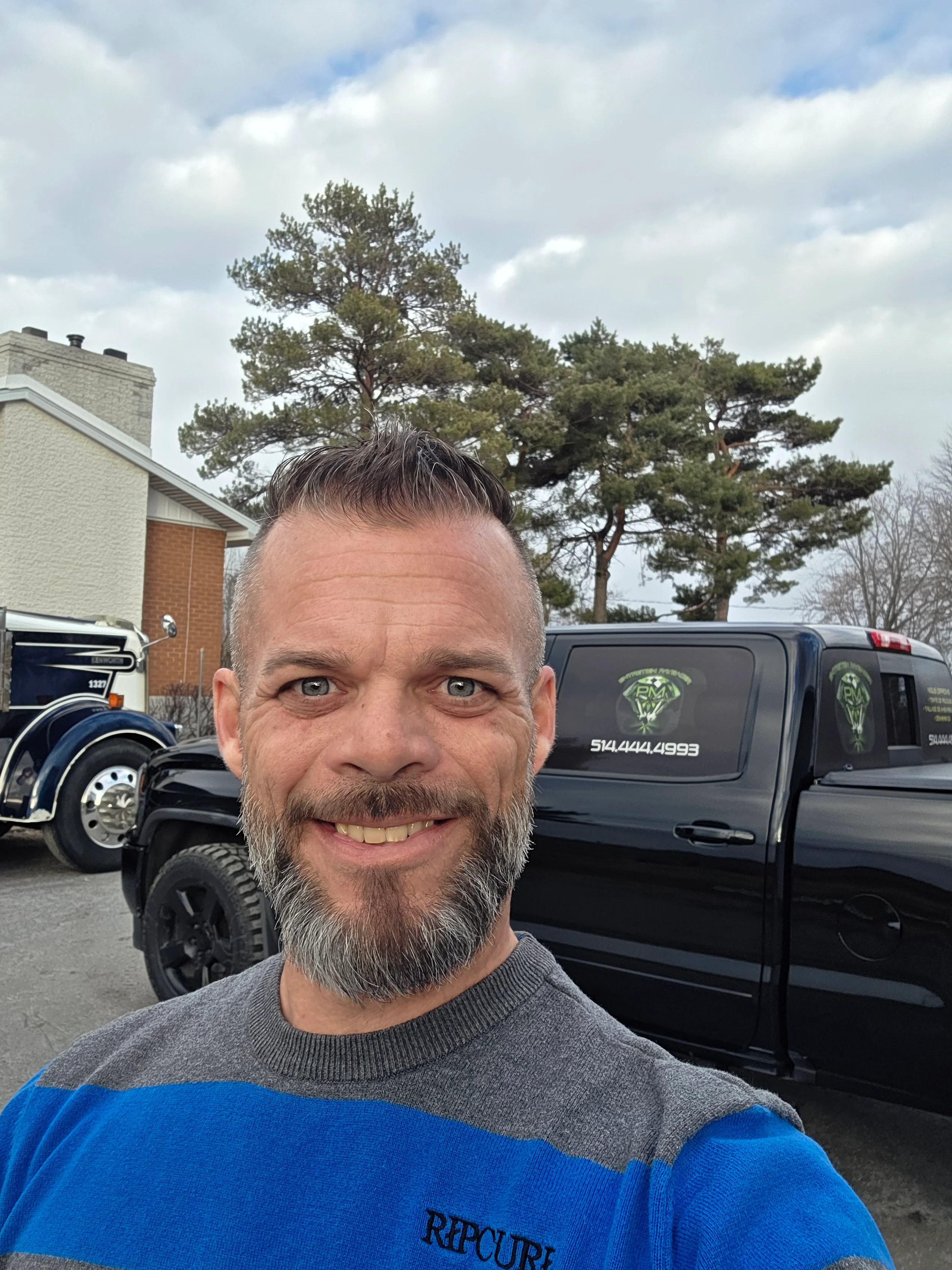 Pascal Michon, fondateur d'Entretien Paysager PM, devant son camion de service